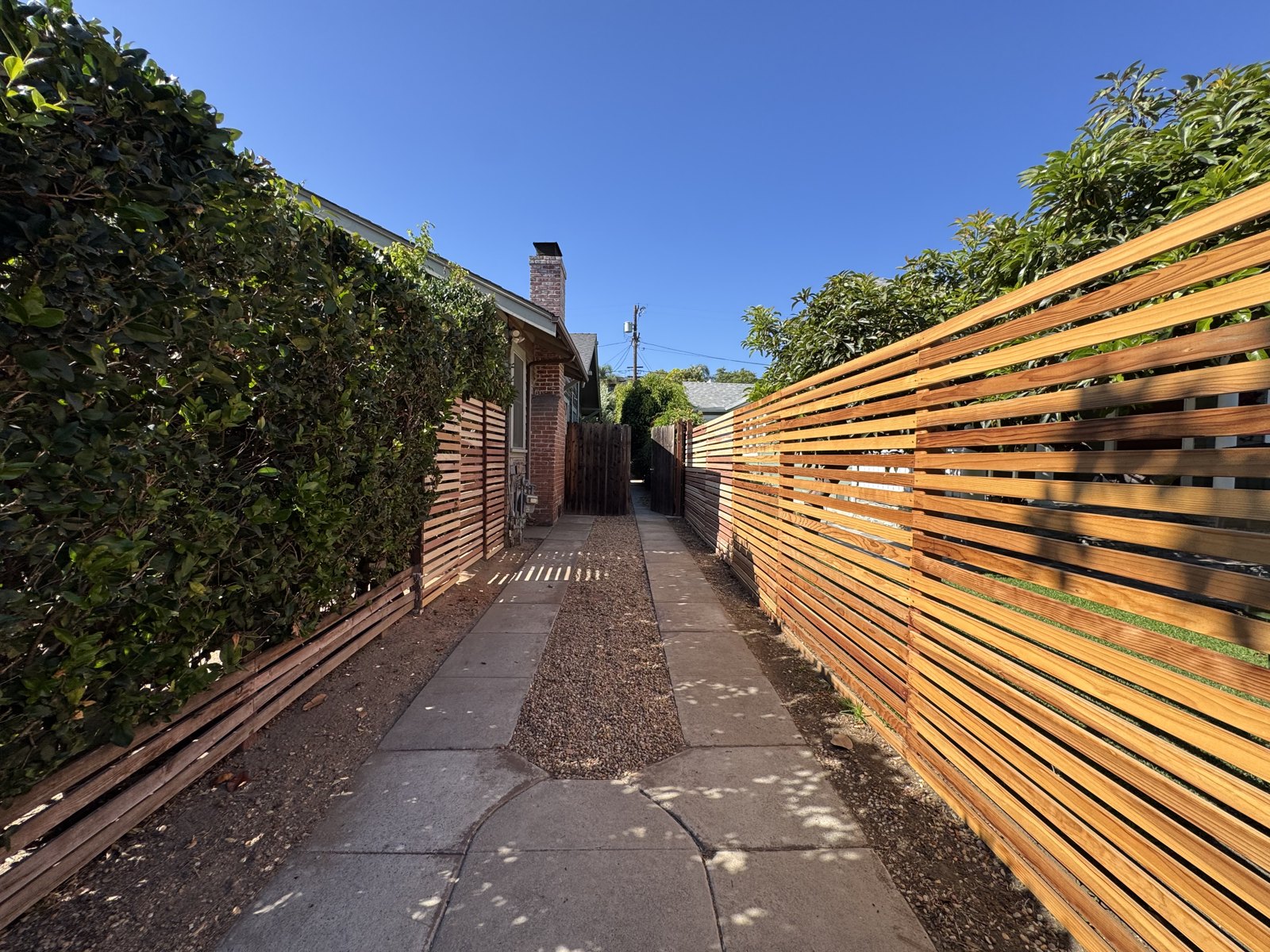 New horizontal cedar slat fence along a side yard walkway
